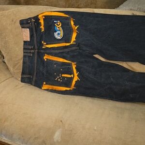 Coogi denim jeans with orange accents and orange back pockets.